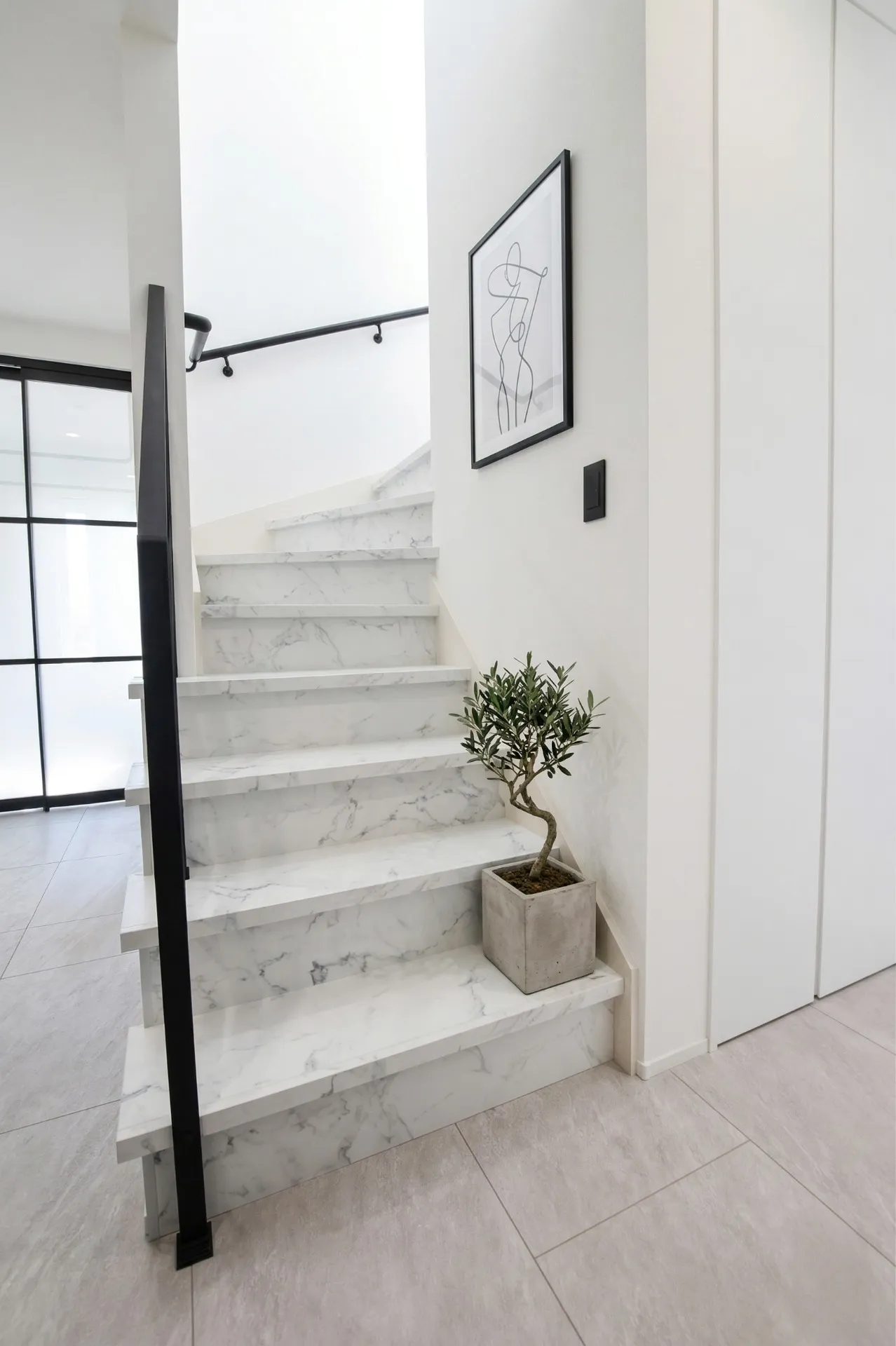 大理石調の階段とアイアン手すりが美しい空間